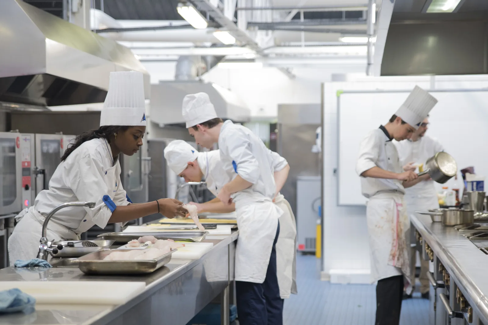 Brigade d'élèves au travail en cuisine