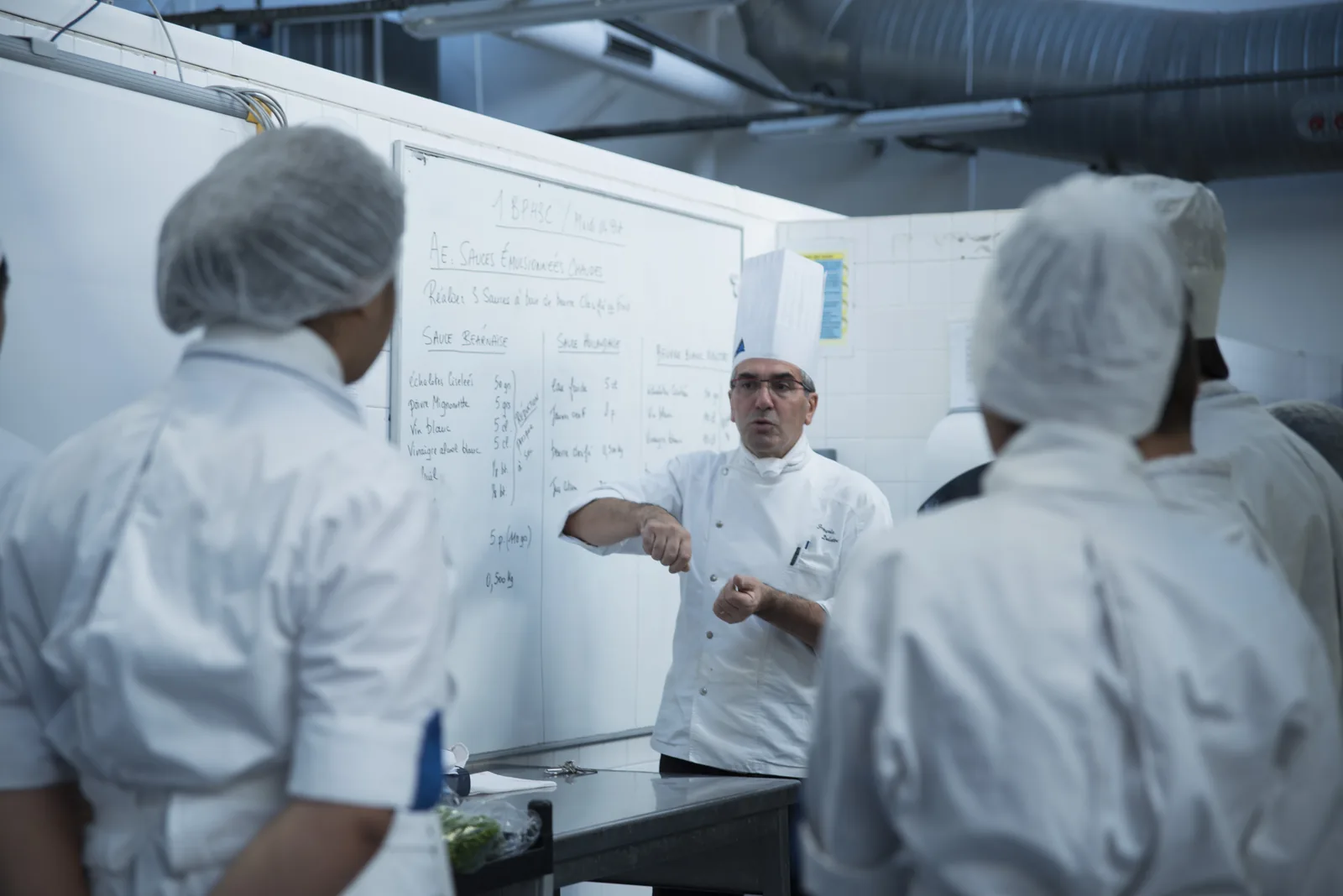 Explication du chef au tableau devant les élèves